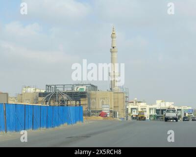 Le Caire, Égypte, avril 27 2024 : chantier de construction d'une nouvelle mosquée avec une structure métallique du dôme et des échafaudages tout le long du minaret du Masjid, Banque D'Images