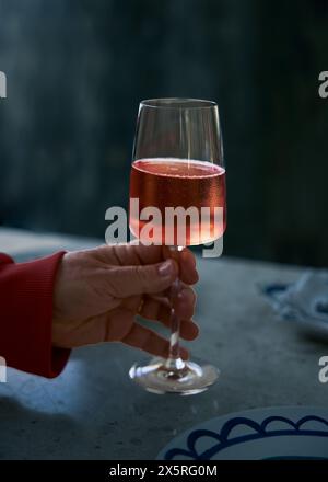 Un verre de vin rouge à la vapeur dans la main d'une femme. Banque D'Images