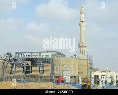 Le Caire, Égypte, avril 27 2024 : chantier de construction d'une nouvelle mosquée avec une structure métallique du dôme et des échafaudages tout le long du minaret du Masjid, Banque D'Images