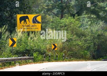 Panneau de signalisation métallique attention éléphants traversant texte attention éléphant traversant la campagne thaïlandaise jour ensoleillé Banque D'Images