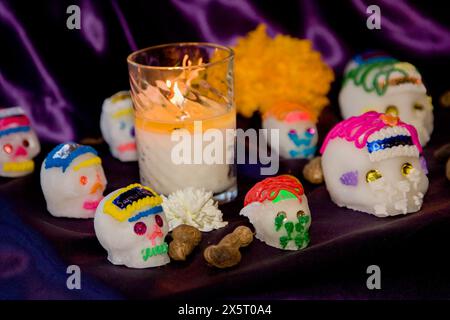Oaxaca ; Mexique ; Amérique du Nord. Jour de la célébration des morts. Sugar Candy Skulls (Calaveras, Calaveritas) et bougie sur un autel honorant les morts. Banque D'Images