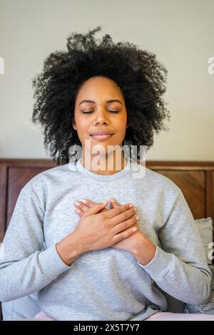 Young woman sitting on bed Banque D'Images