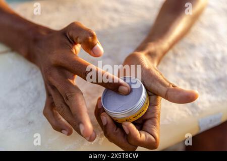 Gros plan des mains masculines appliquant une lotion solaire Banque D'Images