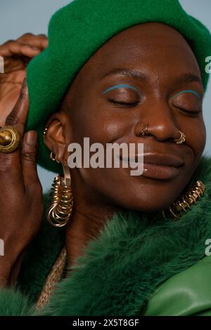 Jeune femme souriante portant des bijoux et un béret Banque D'Images