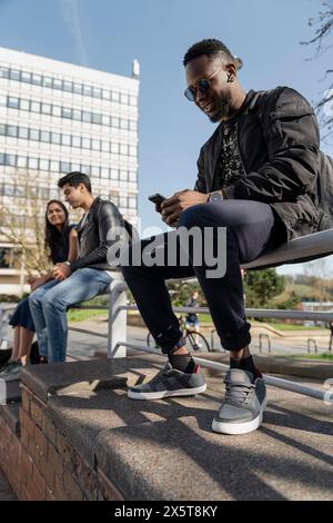 Groupe d'étudiants assis sur le banc sur le campus Banque D'Images