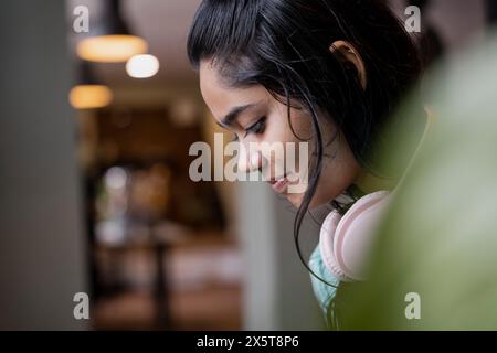 Gros plan d'une jeune femme portant des écouteurs roses Banque D'Images