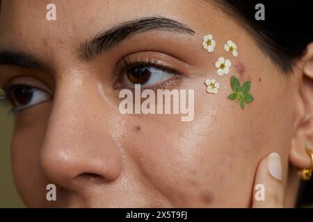 Gros plan du visage de la jeune femme décoré de fleurs séchées Banque D'Images