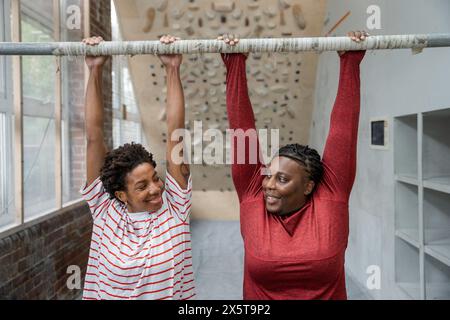 Mère et fille faisant de l'exercice de menton au bar Banque D'Images