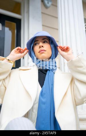 Jeune femme portant un hijab et un chapeau seau Banque D'Images