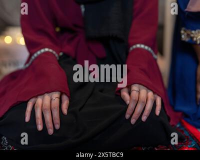 Femme agenouillée tenant les mains sur les genoux pendant la prière du Ramadan à la maison Banque D'Images