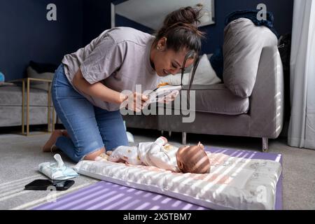 Mère montrant des cartes contrastées à la petite fille nouveau-né à la maison Banque D'Images