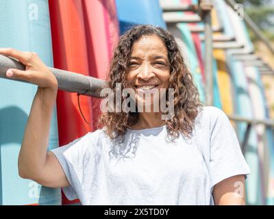 Portrait d'une femme souriante debout à côté du support de paddleboard Banque D'Images