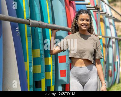 Portrait d'une femme souriante debout à côté du support de paddleboard Banque D'Images