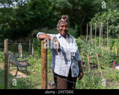 Portrait de femme mature souriante debout dans le jardin Banque D'Images