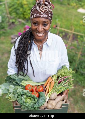 Portrait de femme mature souriante tenant des légumes du jardin Banque D'Images