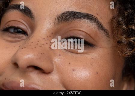 Gros plan d'une femme avec des yeux bruns et des taches de rousseur Banque D'Images