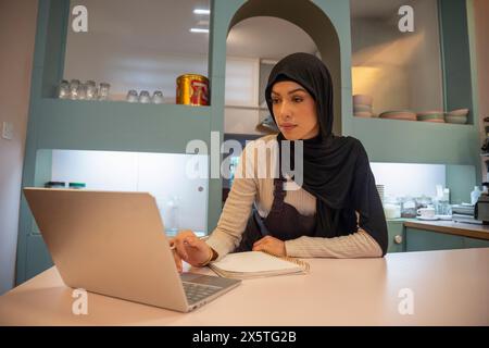 Femme propriétaire de café travaillant sur ordinateur portable Banque D'Images