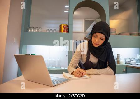 Femme propriétaire de café travaillant sur ordinateur portable Banque D'Images