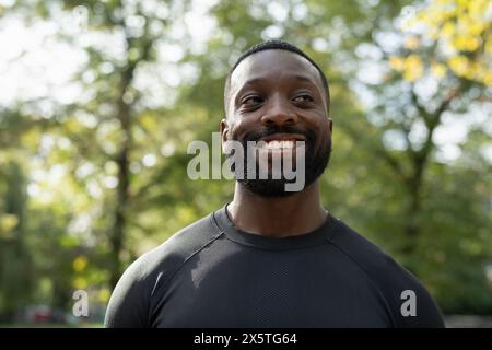 Portrait d'homme souriant debout dans le parc Banque D'Images