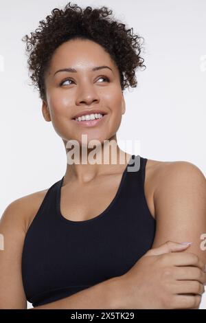 Portrait studio de femme athlétique souriante en top noir Banque D'Images