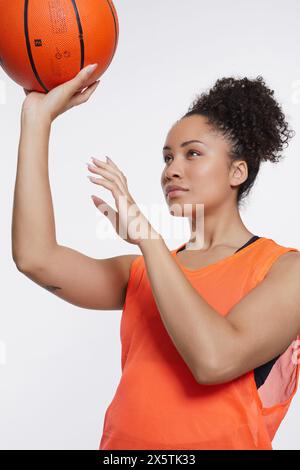 Portrait studio de femme athlétique avec ballon de basket-ball Banque D'Images