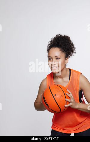 Portrait studio de femme athlétique avec ballon de basket-ball Banque D'Images