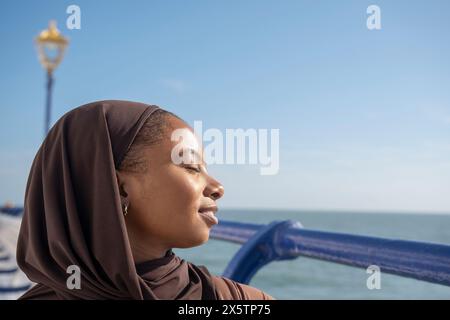 Portrait de femme musulmane avec les yeux fermés par la mer le jour ensoleillé Banque D'Images