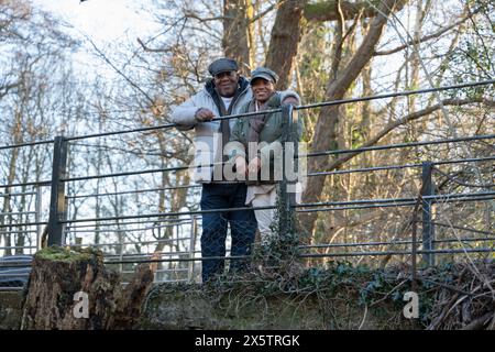 Couple senior debout près de la clôture, regardant la caméra Banque D'Images