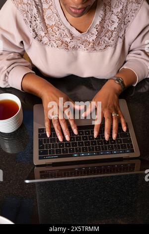 Femmes tapant à la main sur ordinateur portable Banque D'Images