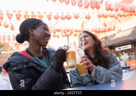 Portrait de deux femmes joyeuses buvant du thé à bulles dans Chinatown Banque D'Images