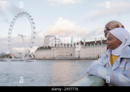 Royaume-Uni, Londres, touristes femmes dans les hijabs regardant le London Eye sur la Tamise Banque D'Images