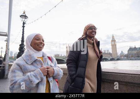 Royaume-Uni, Londres, jeunes femmes touristes dans les hijabs marchant le long de la Tamise Banque D'Images