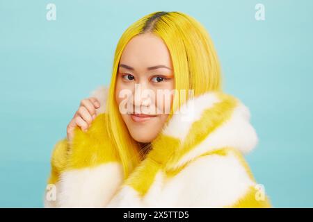 Femme aux longs cheveux jaunes, portant un manteau de fourrure Banque D'Images