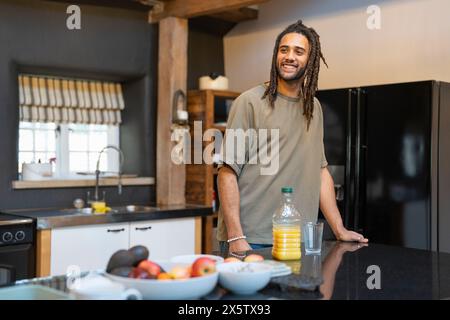 Homme avec des dreads debout dans la cuisine Banque D'Images