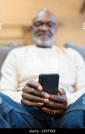 Gros plan d'un homme âgé utilisant un téléphone intelligent Banque D'Images