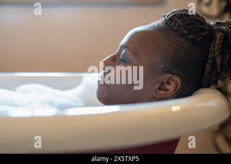 Femme senior prenant un bain moussant Banque D'Images