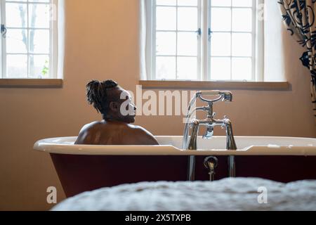 Femme senior prenant un bain moussant Banque D'Images