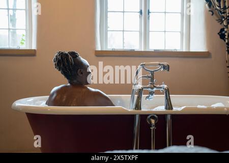 Femme senior prenant un bain moussant Banque D'Images