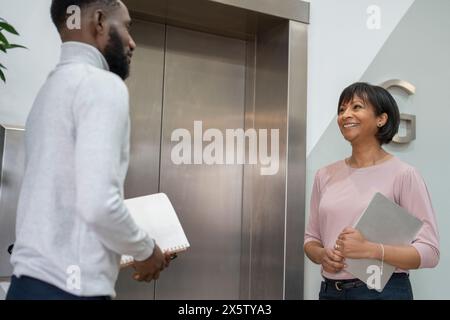 Les gens d'affaires attendent l'ascenseur dans le bureau Banque D'Images