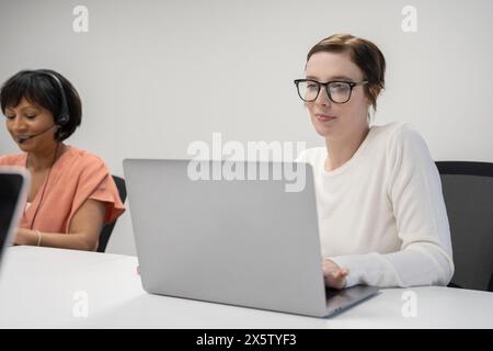 Femmes d'affaires travaillant sur des ordinateurs portables au bureau Banque D'Images