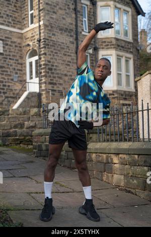 Athlète étirant le bras sur le trottoir Banque D'Images