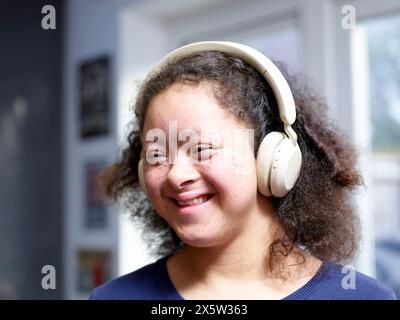Fille atteinte du syndrome de Down portant des écouteurs Banque D'Images