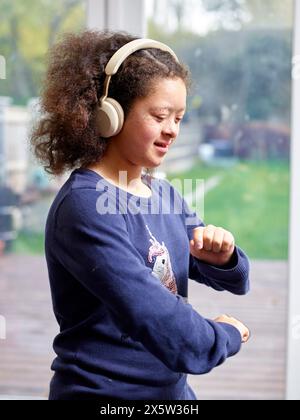 Fille atteinte du syndrome de Down portant des écouteurs Banque D'Images