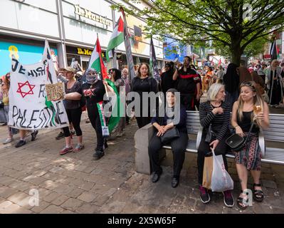 Manchester, Royaume-Uni. 11 mai 2024. Les acheteurs restent assis alors que les manifestants palestiniens passent devant Market Street Manchester. Les manifestants pro-palestiniens ont défilé dans le centre-ville de Manchester, perturbant les achats et les transports publics. C’était la 32ème manifestation consécutive depuis le 7 octobre 2023 à avoir lieu dans la ville. Manchester Royaume-Uni. Crédit : GaryRobertsphotography/Alamy Live News Banque D'Images