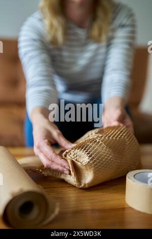 Paquet d'emballage de femme protégé avec du papier vert respectueux de l'environnement ou du papier d'emballage en nid d'abeille sans plastique Banque D'Images