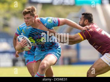 Ethan Harvard des Worriers de Wigan est attrapé par le maillot par Seb Ikahihifo des Huddersfield Giants lors du match Gallagher Premiership au John Smith's Stadium, Huddersfield. Date de la photo : samedi 11 mai 2024. Banque D'Images