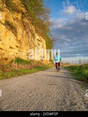 Cycliste masculin chevauchant un vélo pliant sur Steamboat trace, piste cyclable convertie à partir d'un chemin de fer abandonné, près du Pérou, Nebraska, scénographe matinal printanier Banque D'Images