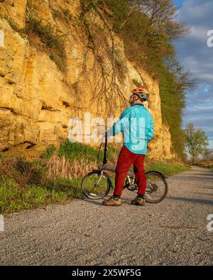 Cycliste masculin senior avec un vélo pliant sur Steamboat trace, piste cyclable convertie à partir d'un chemin de fer abandonné, près du Pérou, Nebraska, printemps matin s. Banque D'Images