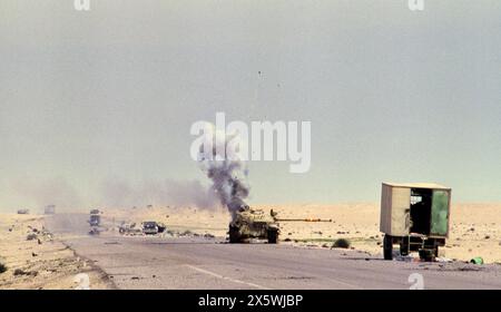 Première Guerre du Golfe : 4 mars 1991 un char irakien abandonné T55 explose, projetant de la fumée et des éclats d'éclats alors qu'il brûle sur la route 801, la route d'Um Qasr, au nord de Koweït City. Banque D'Images