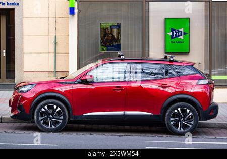 OSTRAVA, RÉPUBLIQUE TCHÈQUE - 19 DÉCEMBRE 2023 : vue latérale d'une voiture rouge vif Peugeot 2008 SUV (P24) garée dans la rue Banque D'Images